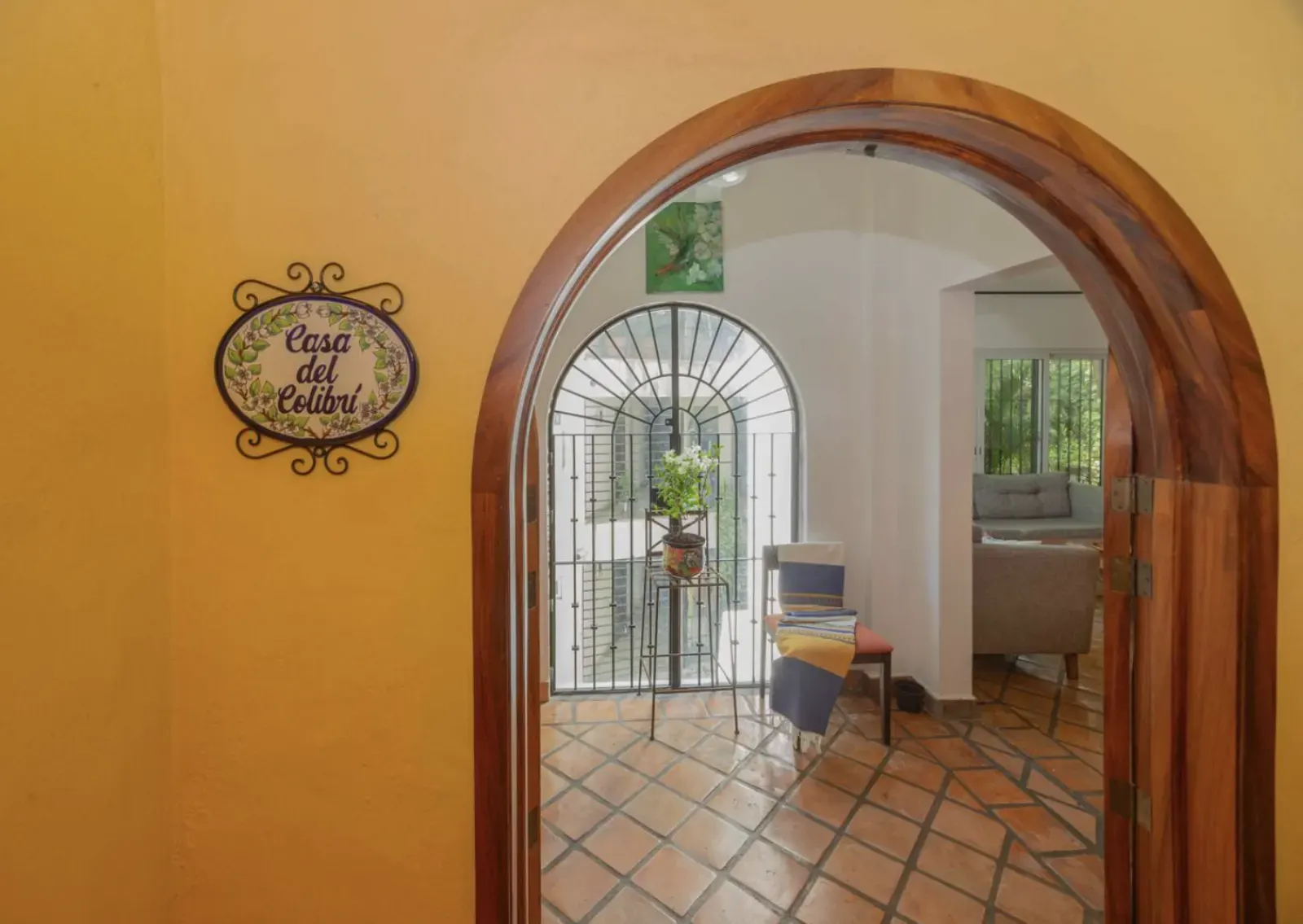 Entrance with wooden arch and Casa del Colibrí sign
